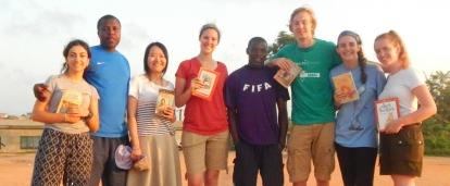Volunteers who teamed up to do childcare work in Ghana pose for a photo at their placement. As part of their community work in Ghana, Projects Abroad volunteers on a Team Trip read books with children at their placement.